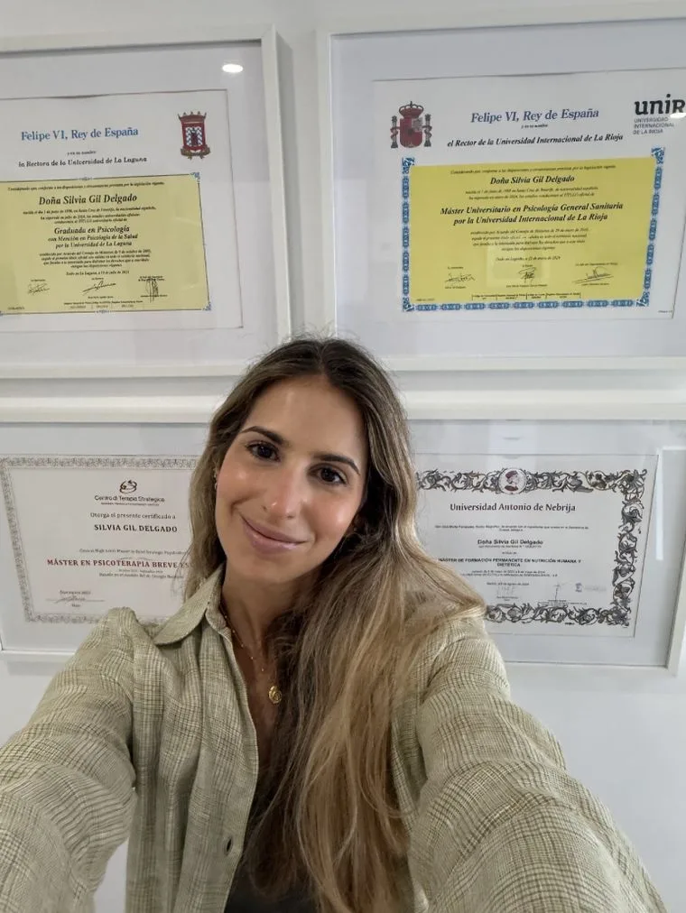 Silvia Gil junto a sus titulaciones